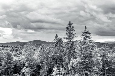 Dağların tepesinde siyah beyaz bulutlar