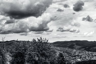 Dağların tepesinde siyah beyaz bulutlar