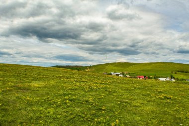 yeşil alan ve bulutlu arkaplanlı dağlar