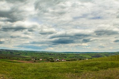 Yeşil çimenli ve tepeli bir manzara.