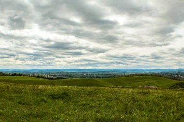 Bir tarlası ve bulutlu gökyüzü olan güzel bir manzara.