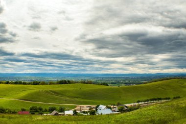 Mavi gökyüzü ve arka planda bulutlar olan yeşil alanlar