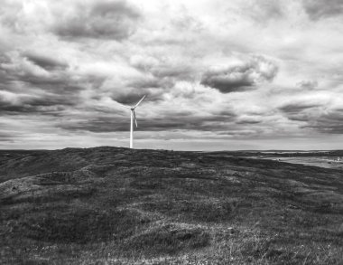 Kasvetli gökyüzünün ortasında bir yel değirmeninin güzel bir görüntüsü.