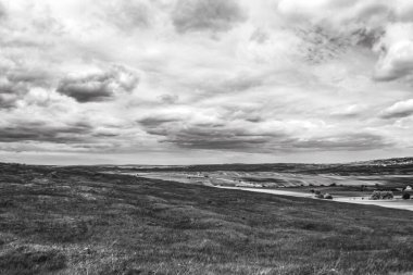 Çimen tarlası ve bulutlu gökyüzü olan güzel bir manzara.