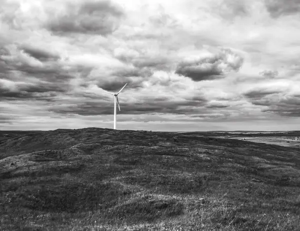 Kasvetli gökyüzünün ortasında bir yel değirmeninin güzel bir görüntüsü.