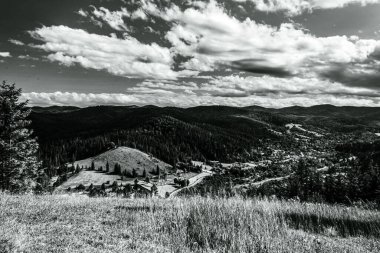 Dağ manzarasının güzel bulutlu gökyüzü ile siyah beyaz fotoğrafı