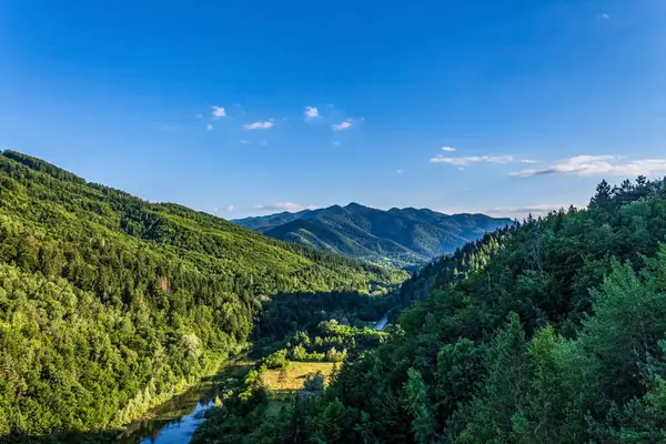 Dağları ve mavi gökyüzü olan güzel bir manzara.