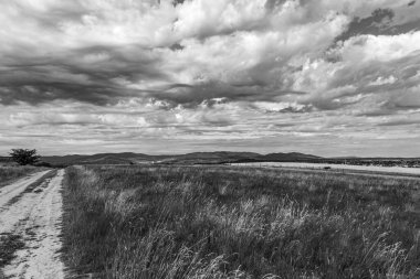 İtalya 'nın sardunya şehrinin tepelerinde siyah ve beyaz bulutlar var.