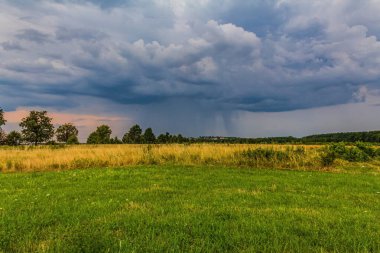 Çayırların ve tarlaların üzerinde fırtına bulutları