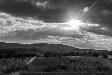 Siyah beyaz bulutlu bir dağ manzarasının dikey görüntüsü.