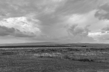 Uzaktaki siyah dağların tepelerinde siyah ve beyaz bulutlar.