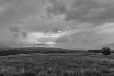 Dağlardaki güzel bulutlar siyah ve beyaz bulutların arka planında.