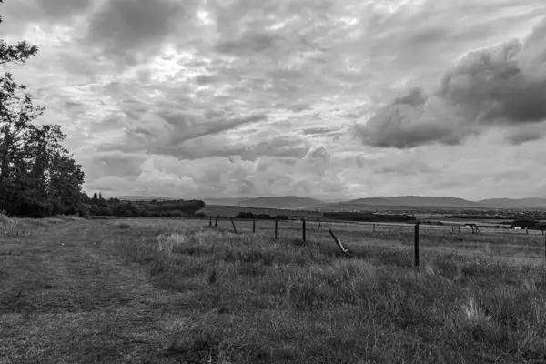 Bir tarlanın üzerinde siyah ve beyaz bulutlar