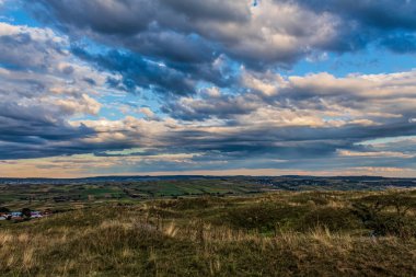 Dağları ve bulutlu gökyüzü olan güzel bir manzara.