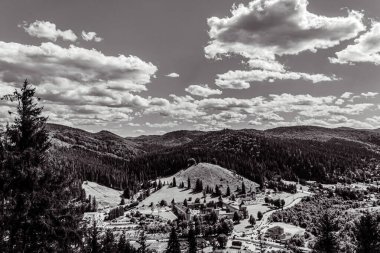 black and white photo from a top of a mountain in the valley. the mountains is a mountain range in the mountains, in the background is