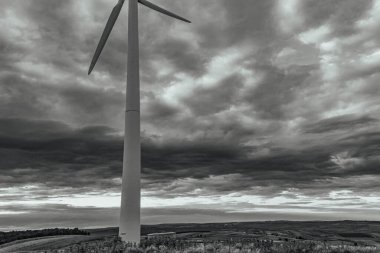 a vertical shot of a wind turbines under cloudy sky