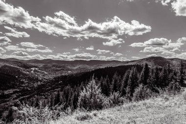black and white photo of a mountain landscape with clouds