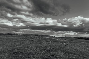 black and white clouds on the horizon over the fields