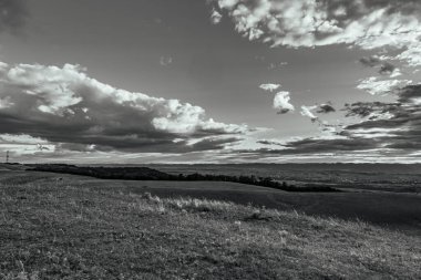 Bulutlu gökyüzü ile güzel bir manzaranın siyah ve beyaz fotoğrafı