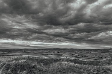 dramatic clouds over hills in black and white