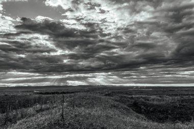 dramatic clouds over a black and white landscape