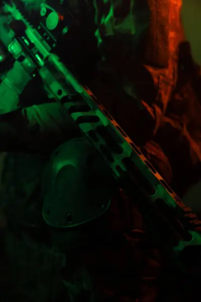 Üniformalı asker. Yüksek kaliteli 4K görüntüler. Tam teçhizatlı kararlı bir asker dumanlı, atmosferik bir sahnede yürüyor. Yoğun ve renkli ışıklandırmayla aydınlatılıyor.. 