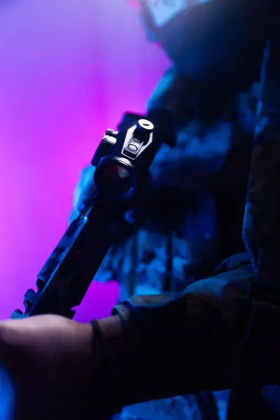 Üniformalı asker. Yüksek kaliteli 4K görüntüler. Tam teçhizatlı kararlı bir asker dumanlı, atmosferik bir sahnede yürüyor. Yoğun ve renkli ışıklandırmayla aydınlatılıyor.. 