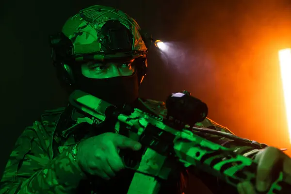 Üniformalı asker. Yüksek kaliteli 4K görüntüler. Tam teçhizatlı kararlı bir asker dumanlı, atmosferik bir sahnede yürüyor. Yoğun ve renkli ışıklandırmayla aydınlatılıyor.. 