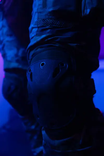 Üniformalı asker. Yüksek kaliteli 4K görüntüler. Tam teçhizatlı kararlı bir asker dumanlı, atmosferik bir sahnede yürüyor. Yoğun ve renkli ışıklandırmayla aydınlatılıyor.. 