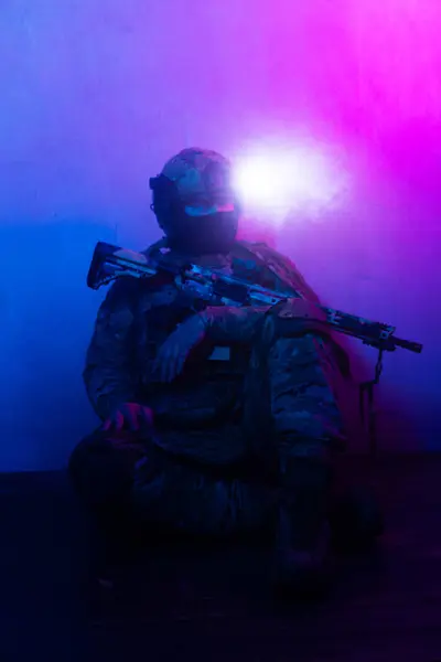 Üniformalı asker. Yüksek kaliteli 4K görüntüler. Tam teçhizatlı kararlı bir asker dumanlı, atmosferik bir sahnede yürüyor. Yoğun ve renkli ışıklandırmayla aydınlatılıyor.. 