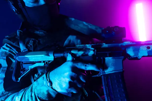 Üniformalı asker. Yüksek kaliteli 4K görüntüler. Tam teçhizatlı kararlı bir asker dumanlı, atmosferik bir sahnede yürüyor. Yoğun ve renkli ışıklandırmayla aydınlatılıyor.. 