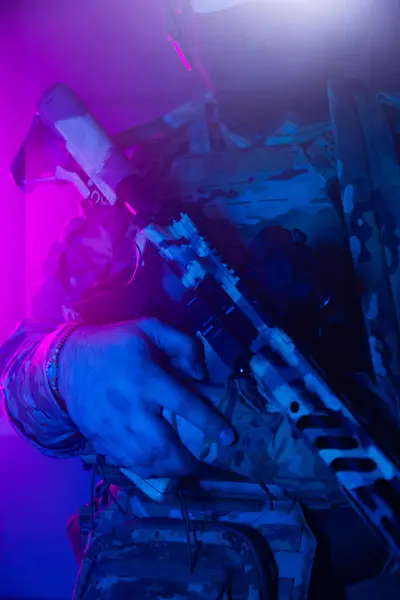 Üniformalı asker. Yüksek kaliteli 4K görüntüler. Tam teçhizatlı kararlı bir asker dumanlı, atmosferik bir sahnede yürüyor. Yoğun ve renkli ışıklandırmayla aydınlatılıyor.. 