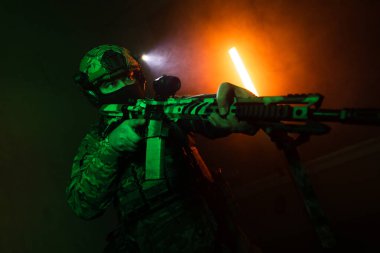 Üniformalı asker. Yüksek kaliteli 4K görüntüler. Tam teçhizatlı kararlı bir asker dumanlı, atmosferik bir sahnede yürüyor. Yoğun ve renkli ışıklandırmayla aydınlatılıyor.. 