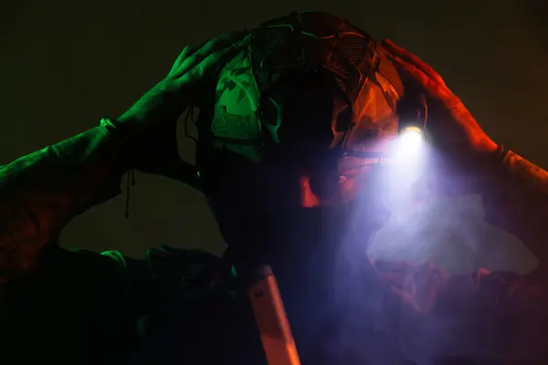 Üniformalı asker. Yüksek kaliteli 4K görüntüler. Tam teçhizatlı kararlı bir asker dumanlı, atmosferik bir sahnede yürüyor. Yoğun ve renkli ışıklandırmayla aydınlatılıyor.. 