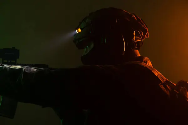 Üniformalı asker. Yüksek kaliteli 4K görüntüler. Tam teçhizatlı kararlı bir asker dumanlı, atmosferik bir sahnede yürüyor. Yoğun ve renkli ışıklandırmayla aydınlatılıyor.. 