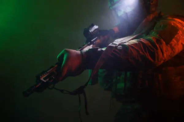 Üniformalı asker. Yüksek kaliteli 4K görüntüler. Tam teçhizatlı kararlı bir asker dumanlı, atmosferik bir sahnede yürüyor. Yoğun ve renkli ışıklandırmayla aydınlatılıyor.. 