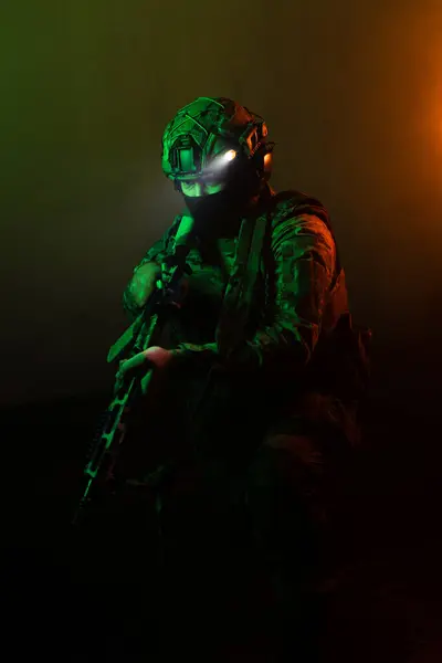 Üniformalı asker. Yüksek kaliteli 4K görüntüler. Tam teçhizatlı kararlı bir asker dumanlı, atmosferik bir sahnede yürüyor. Yoğun ve renkli ışıklandırmayla aydınlatılıyor.. 