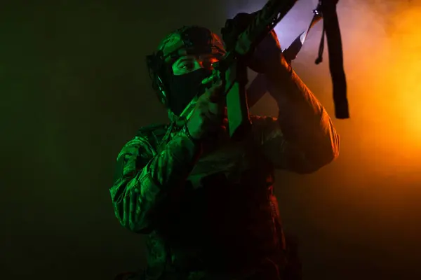 Üniformalı asker. Yüksek kaliteli 4K görüntüler. Tam teçhizatlı kararlı bir asker dumanlı, atmosferik bir sahnede yürüyor. Yoğun ve renkli ışıklandırmayla aydınlatılıyor.. 