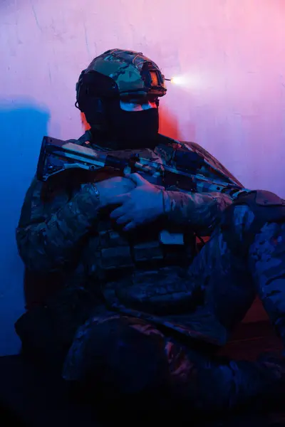 Üniformalı asker. Yüksek kaliteli 4K görüntüler. Tam teçhizatlı kararlı bir asker dumanlı, atmosferik bir sahnede yürüyor. Yoğun ve renkli ışıklandırmayla aydınlatılıyor.. 