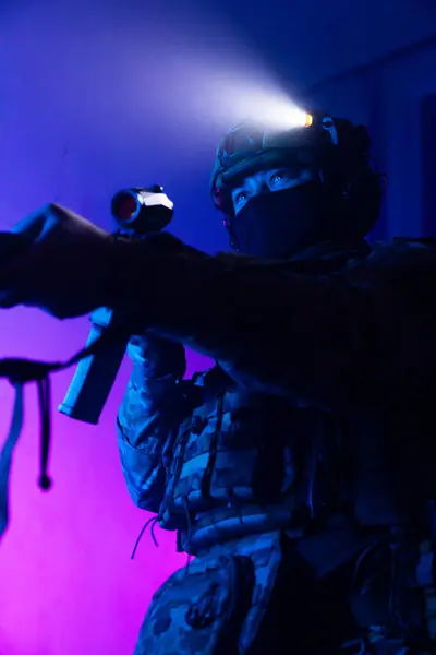 Üniformalı asker. Yüksek kaliteli 4K görüntüler. Tam teçhizatlı kararlı bir asker dumanlı, atmosferik bir sahnede yürüyor. Yoğun ve renkli ışıklandırmayla aydınlatılıyor.. 