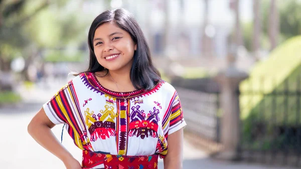 Portrait of a beautiful young indigenous woman in a colorful dress from the Quich.
