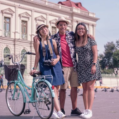 happy friend with blue bicycle posing in city of San Salvador.