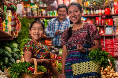 food bazaar in Guatemala, mom and daughter making purchase of food in market  