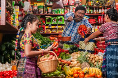 food bazaar in Guatemala, mom and daughter making purchase of food in market  