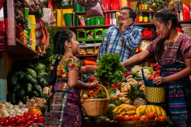 food bazaar in Guatemala, mom and daughter making purchase of food in market  