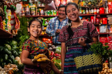food bazaar in Guatemala, mom and daughter making purchase of food in market  