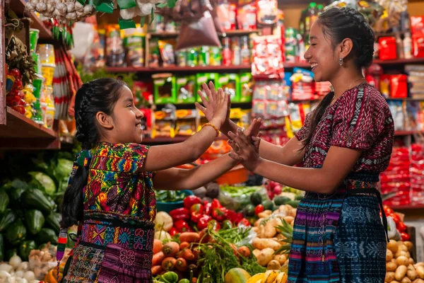 happy latin mom with daughter in food bazaar of Guatemala,