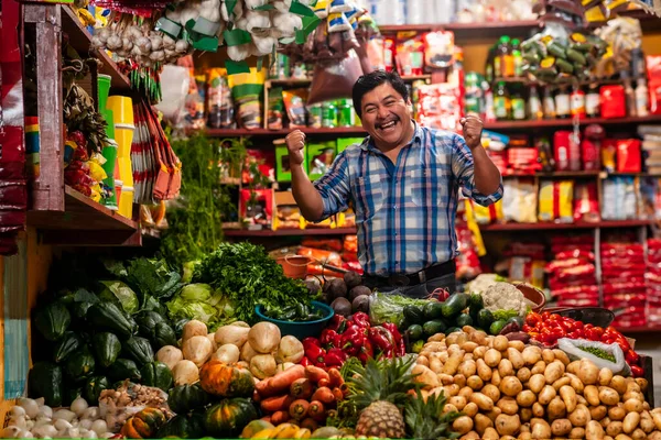 food bazaar in Guatemala, happy latin-american man selling vegetables and fruits   
