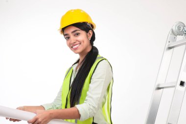 Female architect holding blueprints, smiling on white background.