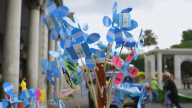 Mavi beyaz bayraklar ve oyuncak yel değirmenlerinin yavaş çekim videosu. 14 Eylül 2022. Guatemala 